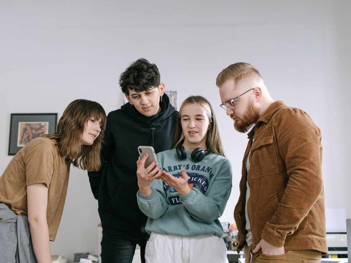 Quattro ragazzi intorno a uno smartphone