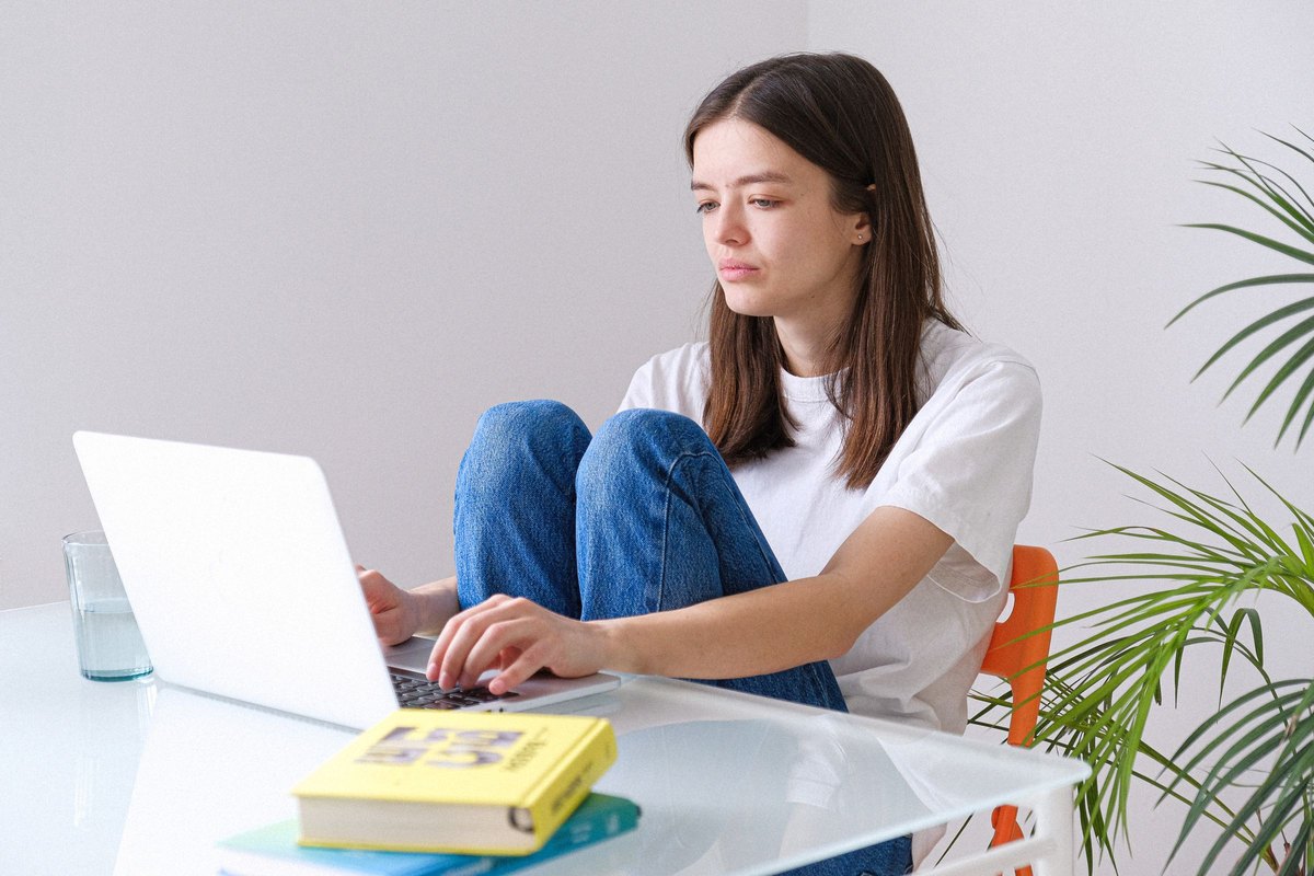 Ragazza che lavora al portatile, seduta alla scrivania
