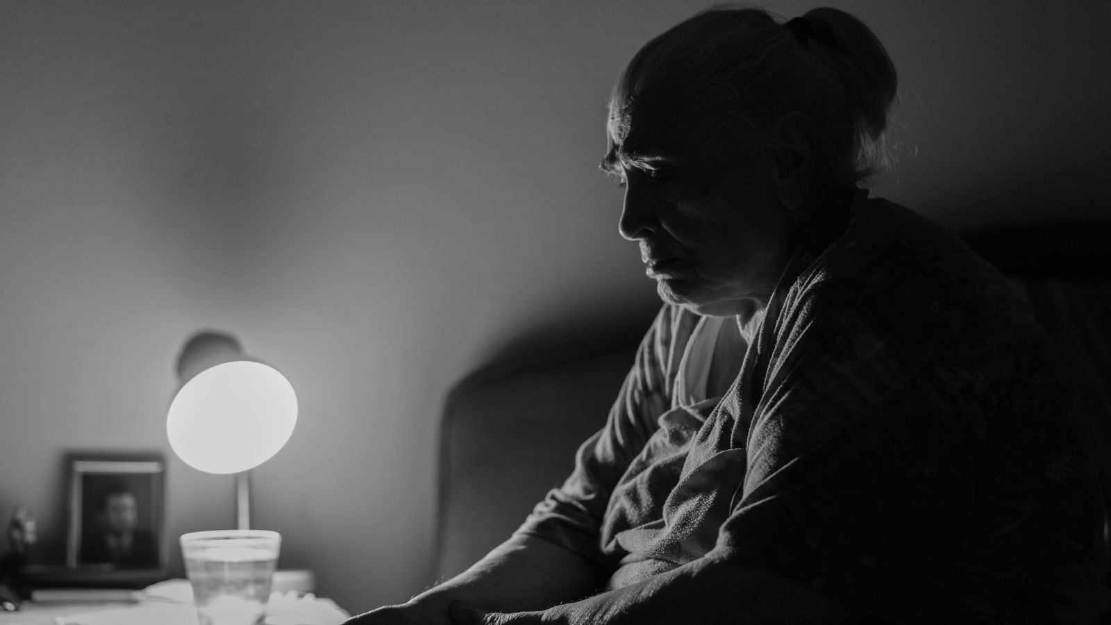 Signora anziana seduta in casa, in bianco e nero